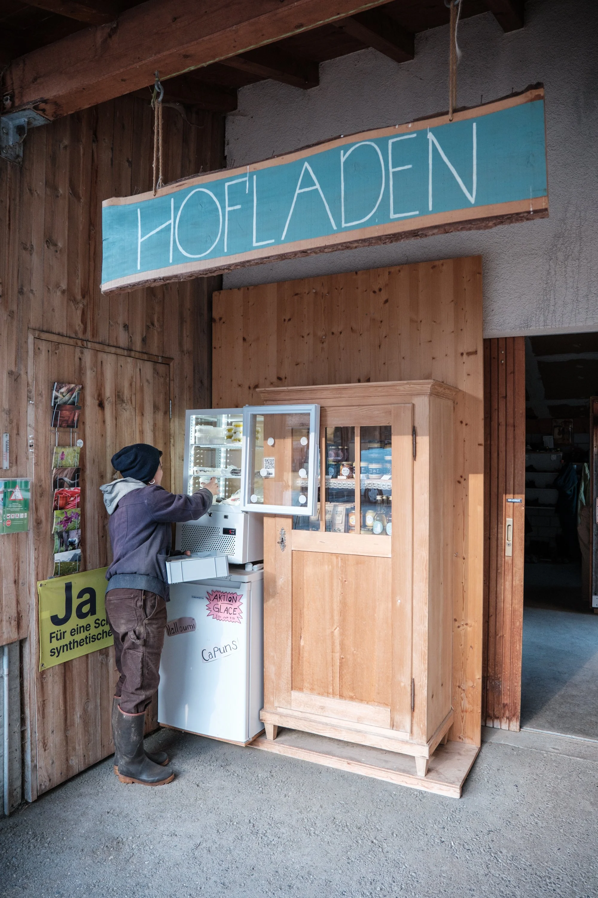 Ein Junge bedient eine Eismaschine vor einem Holzwand-Laden mit einem Schild "Holland".